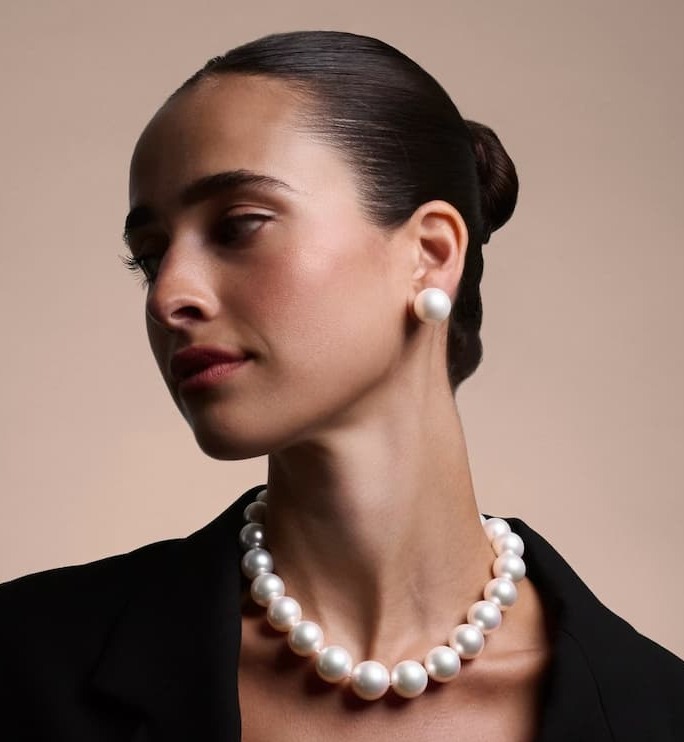 Woman wearing a strand of large pearls and pearl earrings